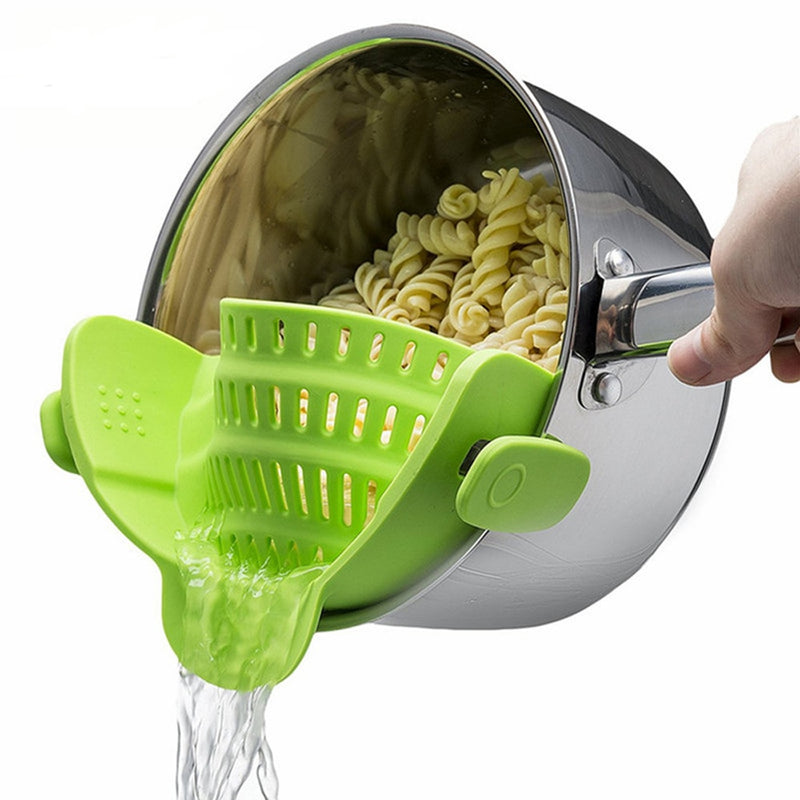 Green Silicone Kitchen Snap N Strain Filter attached to pot pouring water while straining cooked pasta spirals.
