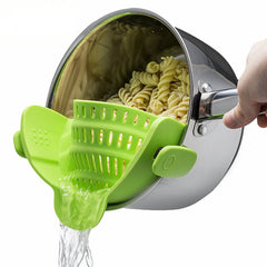 Hand using Silicone Kitchen Snap N Strain Filter to drain water from cooked rotini pasta in pot