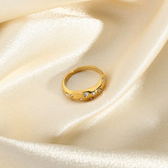 Gold Snake-Shape Ring with embedded clear gemstones displayed on soft ivory satin fabric background