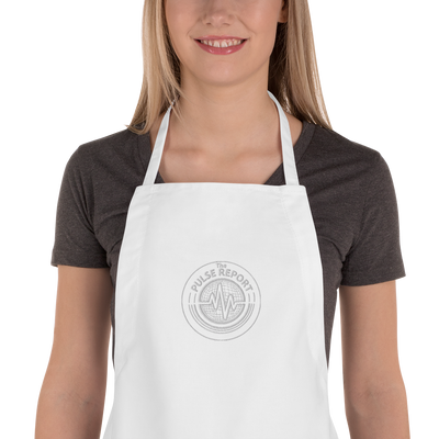 Woman wearing a white @Pulse Report Embroidered Apron | Liberty Bags 5502 with a round embroidered logo on front