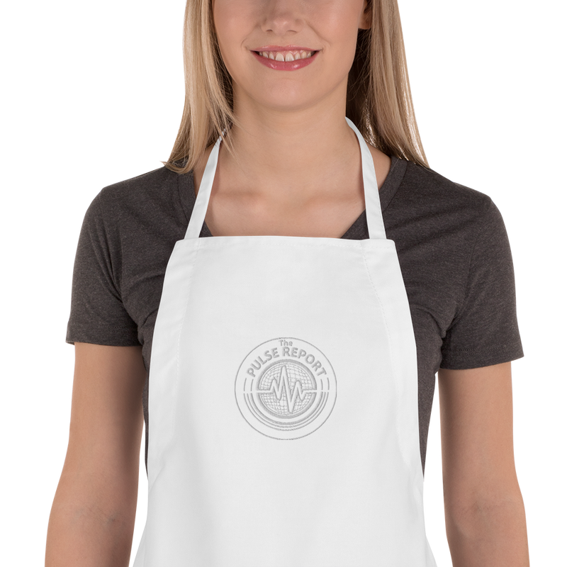 Woman wearing a white @Pulse Report Embroidered Apron | Liberty Bags 5502 with a round embroidered logo on front