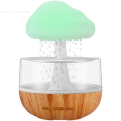 Desktop Rain Cloud Humidifier with wooden base and green cloud-shaped top releasing mist droplets inside a transparent tank.