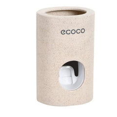 Wall Mount Automatic Toothpaste Dispenser in beige with a visible white dispensing button and eco-friendly branding.