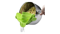 Green Silicone Pot Strainer attached to saucepan draining water from cooked pasta in a stainless steel pot