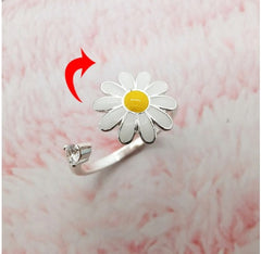 Silver Fidget Spinner Rotatable Ring For Women with white and yellow daisy design and small clear stone on pink background