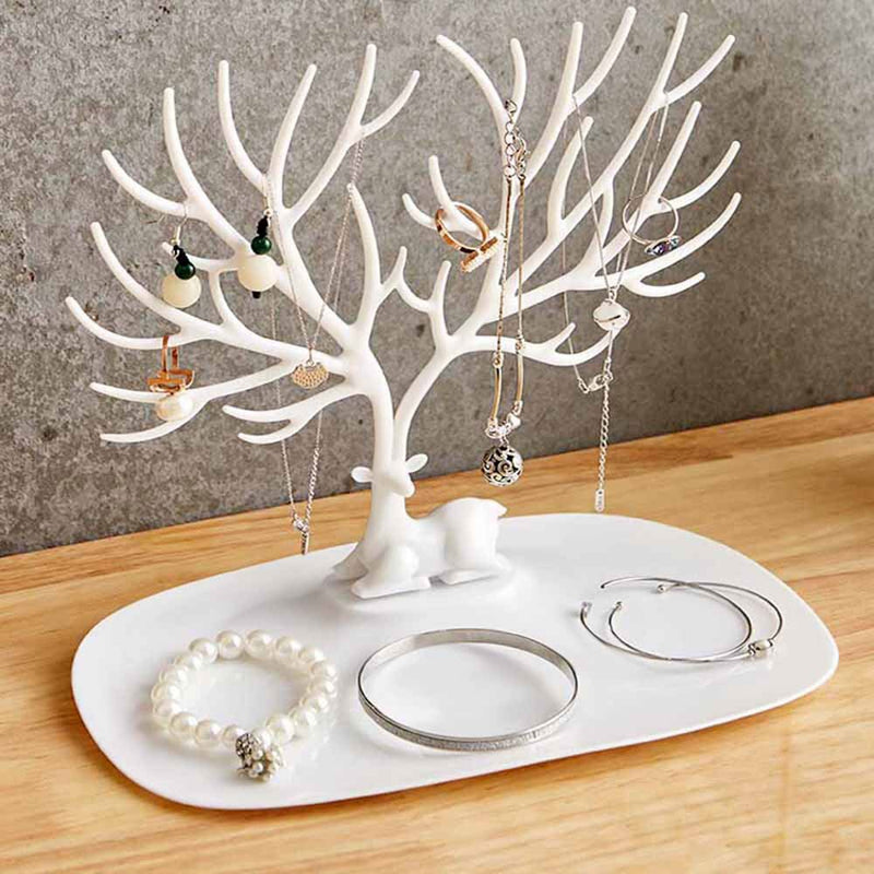 White Deer Jewelry Holder with multiple hanging necklaces and placed bracelets on a wooden surface