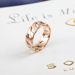 Rose gold braided design Cassie Ring displayed on a white background with faint text beneath.