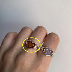 Hand wearing two heart-shaped rings with contrasting colors, featuring the Creative Love Heart Ring design.