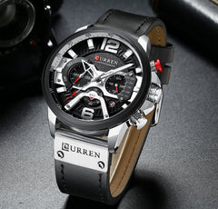 Military Leather Chronograph Wristwatch with black dial, silver case, red accents, and black leather strap on a dark surface.