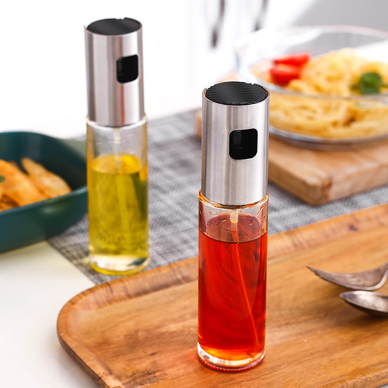 Kitchen Condiment Bottle with stainless steel top containing red and yellow liquid on a wooden tray near food dishes.
