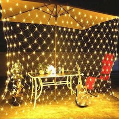 Net Mesh Solar Fairy Lights hanging around a patio table with guitar and red chair, glowing warmly at night.