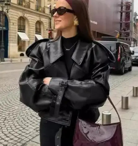 Woman wearing a black Matte Leather Jacket with puffed sleeves and oversized collar on a city street.