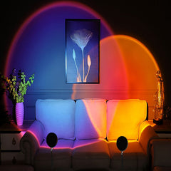 Sunset Lamp casting colorful overlapping blue, purple, red, and orange light on a white couch and wall art.