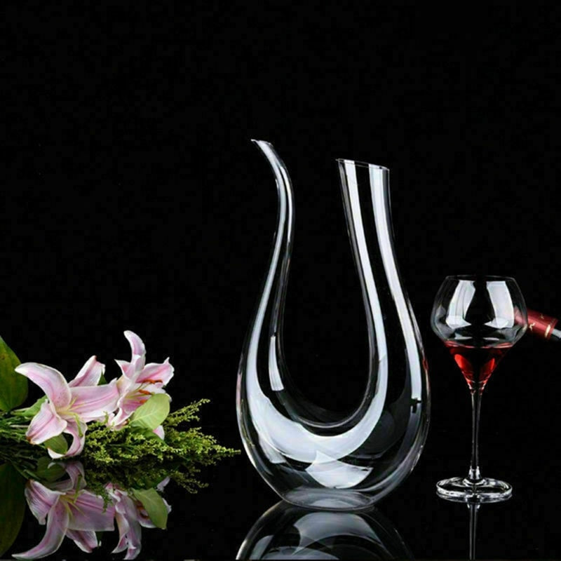 Crystal U-shaped 1500ml Wine Decanter next to a glass of red wine and pink lilies on a reflective black surface