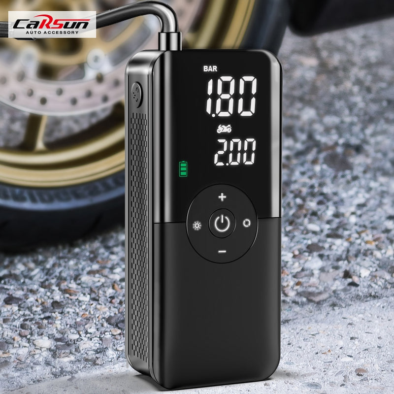 Portable Inflator Pump digital tire pressure display and control buttons next to motorcycle wheel on gravel surface