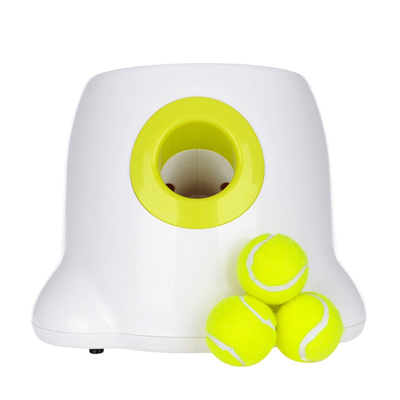 White and yellow Dog pet Tennis Launcher with three bright yellow tennis balls stacked beside it